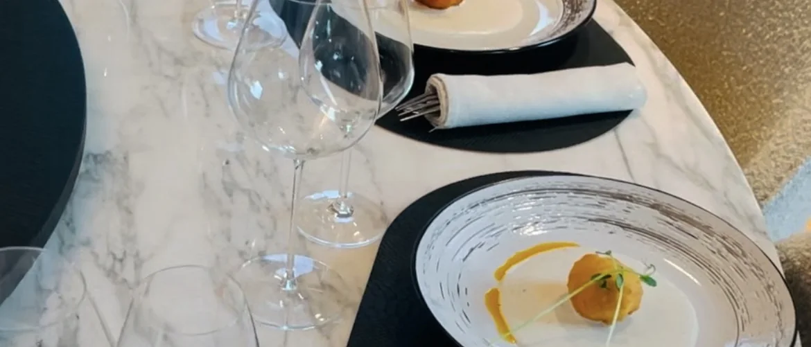 Table dressée pour un service AWASE : marbre, verres à vin et amuse-bouche à l'assiette