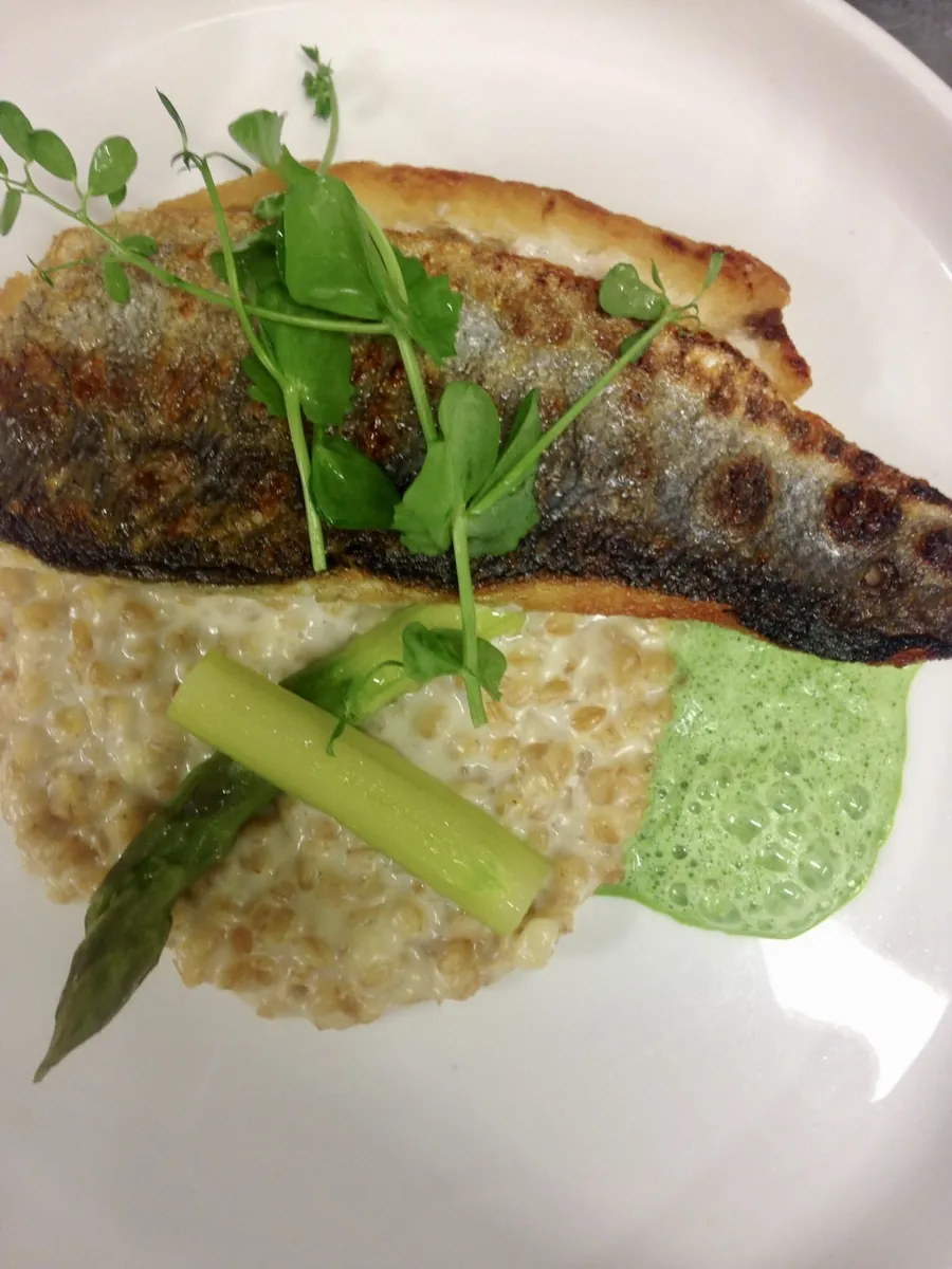 Filet de poisson croustillant, crème d'herbes et asperge, dressé à l'assiette